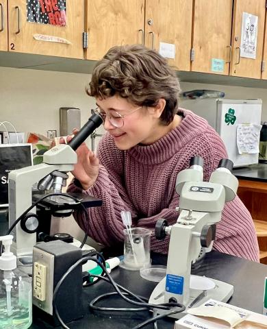 student looking in microscope