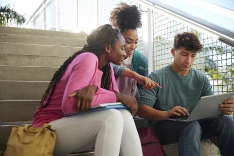 3 students looking at laptop