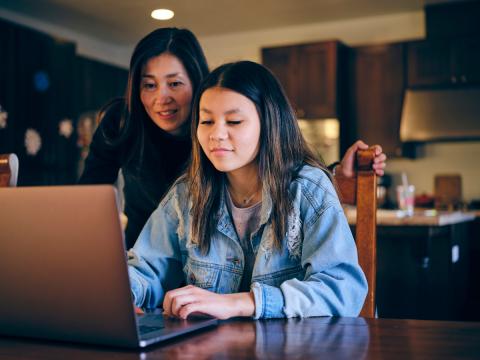 mother and daughter looking at laptop